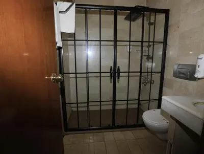 a bathroom with a shower with a toilet and a door at Nil Hotel İstanbul City Center in Istanbul