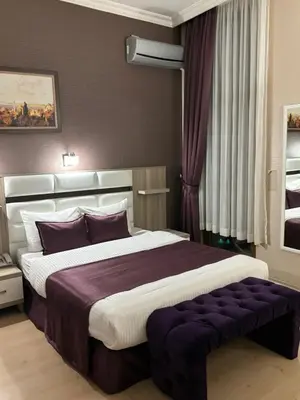 a bedroom with a large bed with purple pillows at Nil Hotel İstanbul City Center in Istanbul