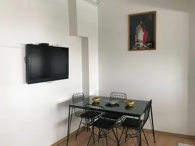 a black table with chairs and a tv on a wall at Apartment sultanahmet in Istanbul