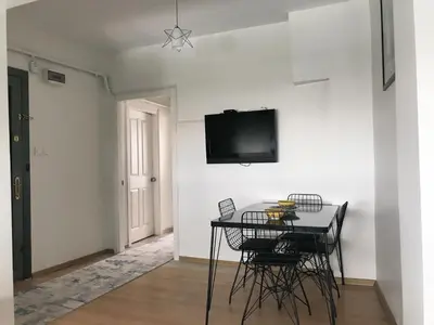 a dining room with a table and a tv on a wall at Apartment sultanahmet in Istanbul