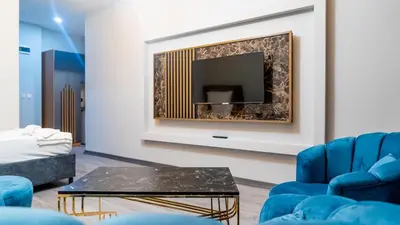 a living room with blue chairs and a fireplace at GRAND MOON HOTEL in Esenyurt