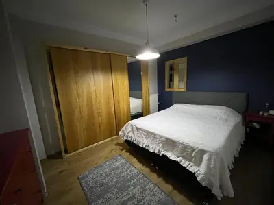 a bedroom with a white bed and a wooden cabinet at Bosphorus waterfront flat, Cengelköy in Istanbul