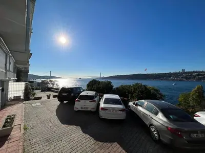 three cars parked in a parking lot next to the water at Bosphorus waterfront flat, Cengelköy in Istanbul