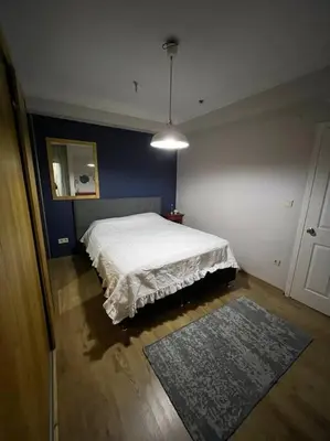 a bedroom with a white bed and a blue wall at Bosphorus waterfront flat, Cengelköy in Istanbul