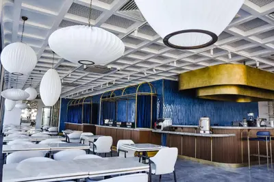 a restaurant with tables and white chairs and lights at Park Inn by Radisson Yalova City Center in Yalova