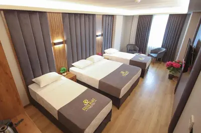 a hotel room with three beds and a television at Hotel And free shuttle in Istanbul