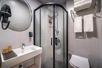 a bathroom with a shower and a sink and a mirror at Hotel And free shuttle in Istanbul