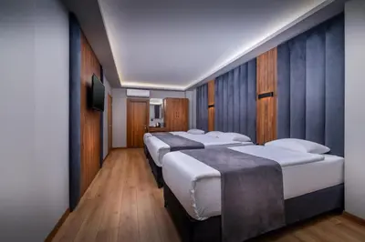 a row of four beds in a hotel room at Hotel And free shuttle in Istanbul