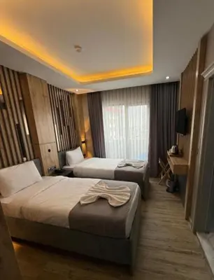 a hotel room with two beds and a television at Hotel And free shuttle in Istanbul