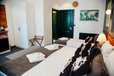 a hotel room with three beds and a green door at Istiklal Street Taksim House Yamalya Hotel in Istanbul