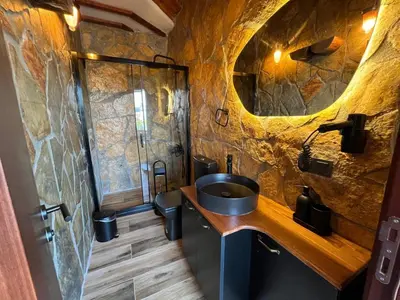 a bathroom with a sink and a stone wall at Olinda Hotel & Spa in Sile