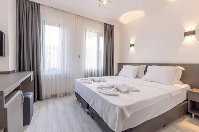 a hotel room with a large bed with white sheets at Olinda Hotel & Spa in Sile