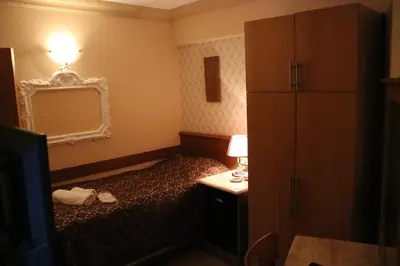 a small bedroom with a bed and a mirror at Grand Peninsula Hotel in Istanbul