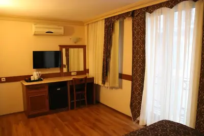 a room with a desk with a television and a window at Grand Peninsula Hotel in Istanbul
