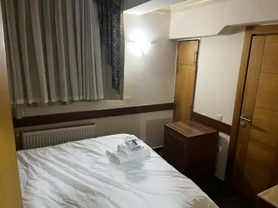 a small bedroom with a white bed and a mirror at Grand Peninsula Hotel in Istanbul