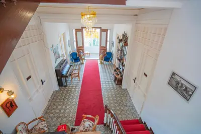 a hallway with a red carpet and blue chairs at Laden Palas Prince's Island Historical Mansion in Adalar