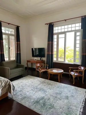 a living room with a bed and chairs and windows at Laden Palas Prince's Island Historical Mansion in Adalar