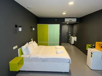 a bedroom with a white bed with a green wall at Aderans Hotel in Istanbul