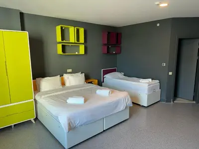 two beds in a room with yellow and green walls at Aderans Hotel in Istanbul