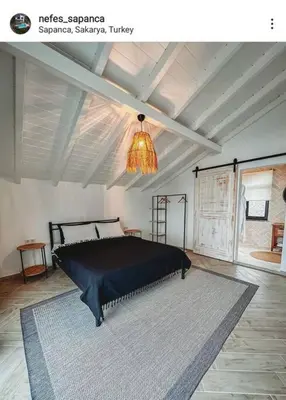 a bedroom with a black bed and a chandelier at Nefes Vılla Sapanca in Sakarya