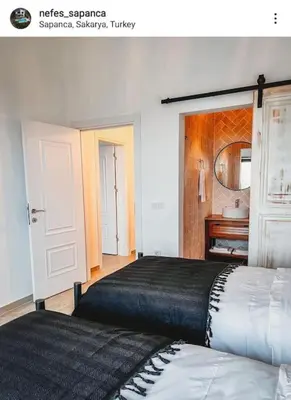 a bedroom with two beds and a bathroom with a sink at Nefes Vılla Sapanca in Sakarya
