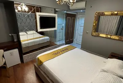 a bedroom with two beds and a mirror and a television at Sahra Airport Hotel in Istanbul