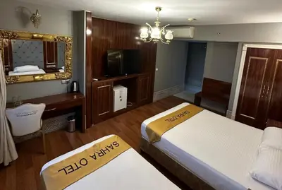 a hotel room with two beds and a mirror at Sahra Airport Hotel in Istanbul