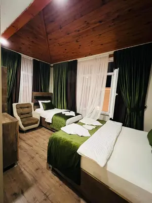 a hotel room with two beds and a chair at Bona apart in Istanbul