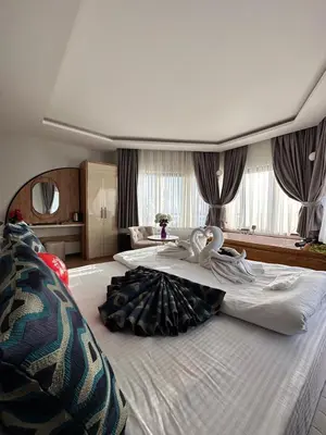 a large hotel room with two beds with a woman on it at Newalla Hotel Old City in Istanbul