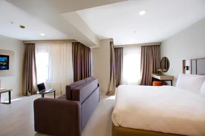 a hotel room with a large bed and a chair at Joy Taksim in Istanbul