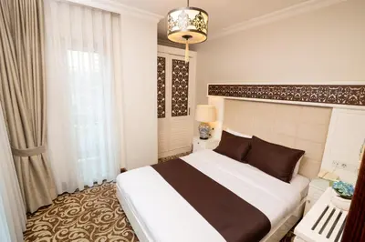a bedroom with a large bed and a chandelier at Şişli Luxury K Suites Hotel in Istanbul