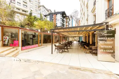 a restaurant with tables and chairs on a city street at Lausos Palace Hotel Şişli in Istanbul