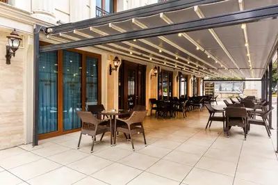 an outdoor patio with tables and chairs and awnings at Lausos Palace Hotel Şişli in Istanbul