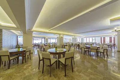 a restaurant with tables and chairs in a room at Lausos Palace Hotel Şişli in Istanbul
