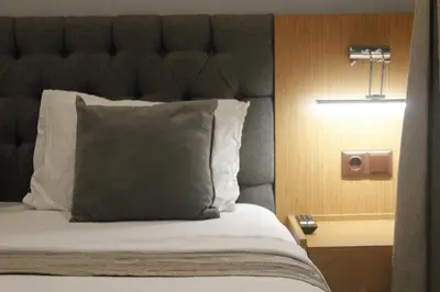 a bedroom with a bed with a black headboard and a pillow at Ada Life Hotel in Istanbul