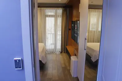 a room with two beds and a television and a bedroom at Ada Life Hotel in Istanbul