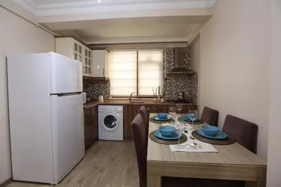 a kitchen with a table and a white refrigerator at Overland Residence in Istanbul