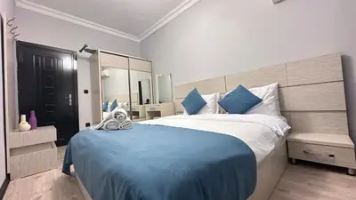a bedroom with a large bed with a blue blanket at Overland Residence in Istanbul