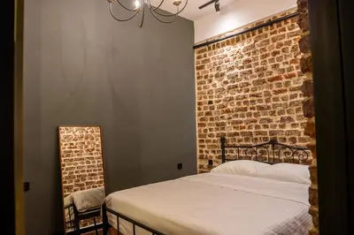 a bedroom with a brick wall and a bed at Alness Residence in Istanbul