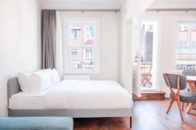 a white bedroom with a bed and a window at Homie Suites - Historical Apartments in the center of Beşiktaş in Istanbul