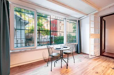 a table and chairs in a room with windows at Homie Suites - Modern Apartments Nearby Istıklal Street & Galata Tower in Istanbul
