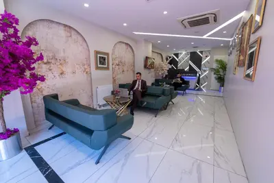 a lobby with blue chairs and a man in a suit at Meros Hotel in Istanbul