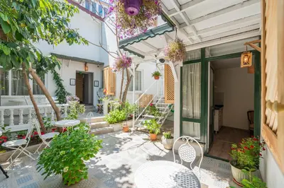 a patio with tables and chairs and potted plants at Aya Butik Otel in Buyukada
