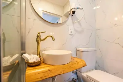 a bathroom with a sink and a mirror and a toilet at Aya Butik Otel in Buyukada