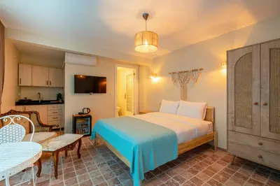 a bedroom with a large bed and a kitchen at Aya Butik Otel in Buyukada