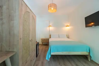a bedroom with a bed and a flat screen tv at Aya Butik Otel in Buyukada