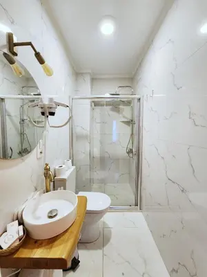 a white bathroom with a sink and a shower at Aya Butik Otel in Buyukada