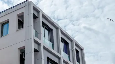 a white building with an airplane flying in the sky at Homie Suites - Newly-constructed Apartment Complex in Beşiktaş in Istanbul