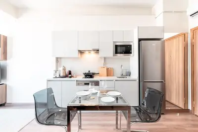 a kitchen with a table and chairs and a refrigerator at Homie Suites - Newly-constructed Apartment Complex in Beşiktaş in Istanbul