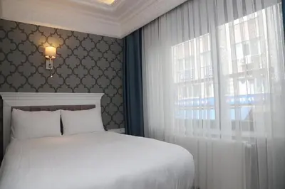 a bedroom with a white bed and a window at Novus Hotel İstanbul in Istanbul